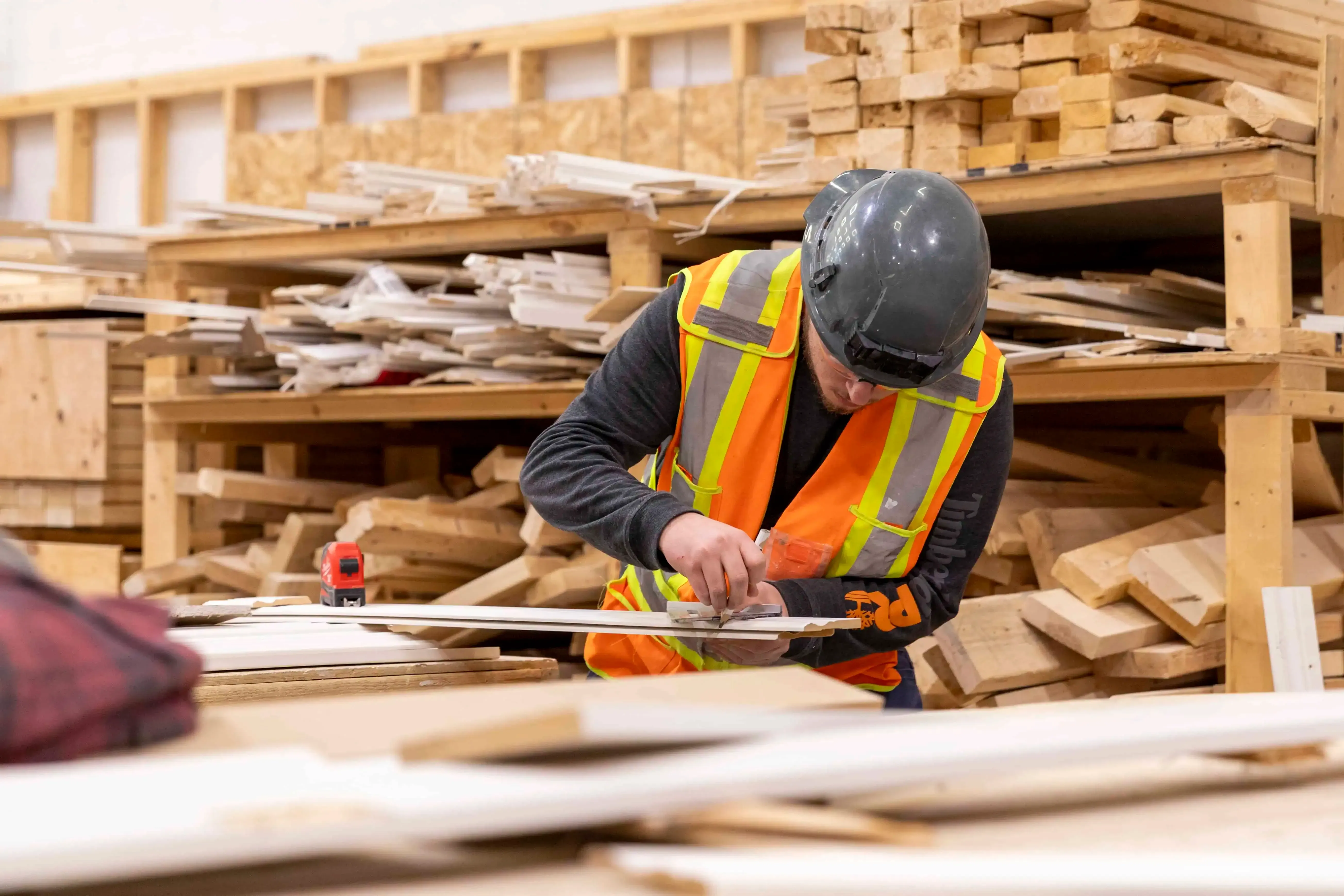 Carpenter measuring lumber for custom millwork on a Great River, NY home renovation.